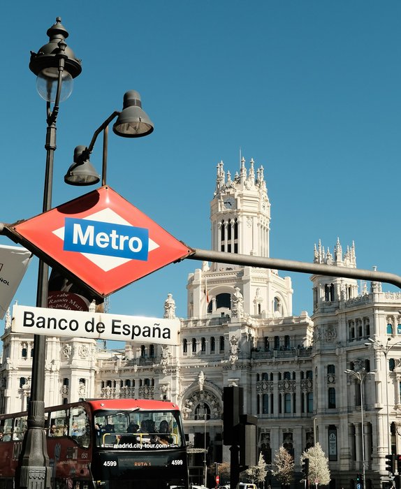 Autobús turístico junto a la parada de Metro Banco de España, con el Palacio de Cibeles al fondo