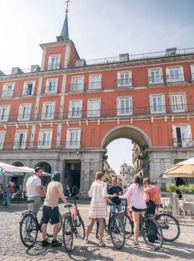 Grupo de bike tour bajo el arco de la Plaza Mayor de Madrid