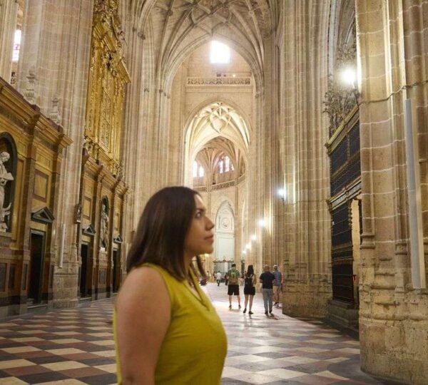 Visitor walking through the nave of Segovia Cathedral, Spain