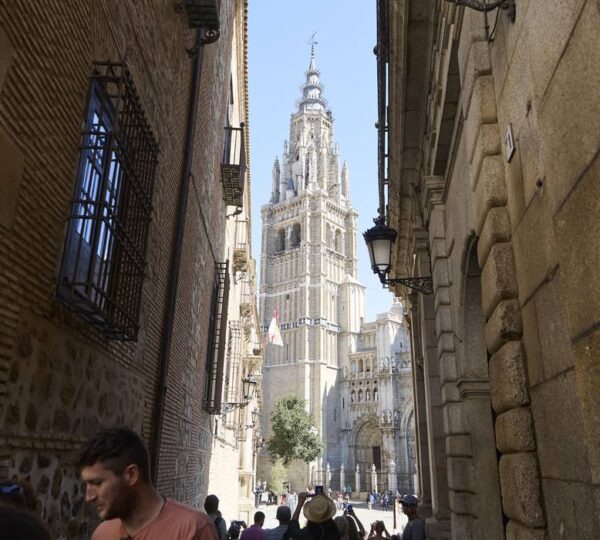 Toledo Cathedral tower framed by a narrow old town alley