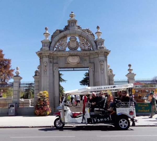 Tuk-tuk con turistas frente a la Puerta del Príncipe del Retiro